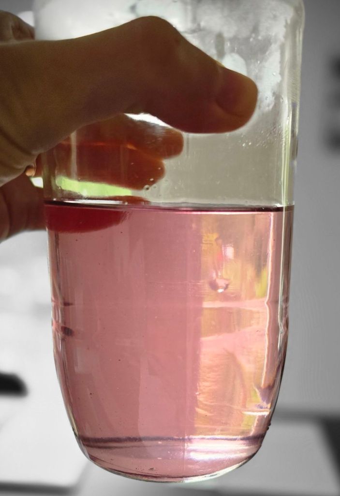 Bocal en verre contenant le sirop de violette rose terminé