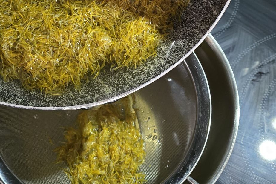 Filtration de l’infusion de pissenlit à travers une passoire fine