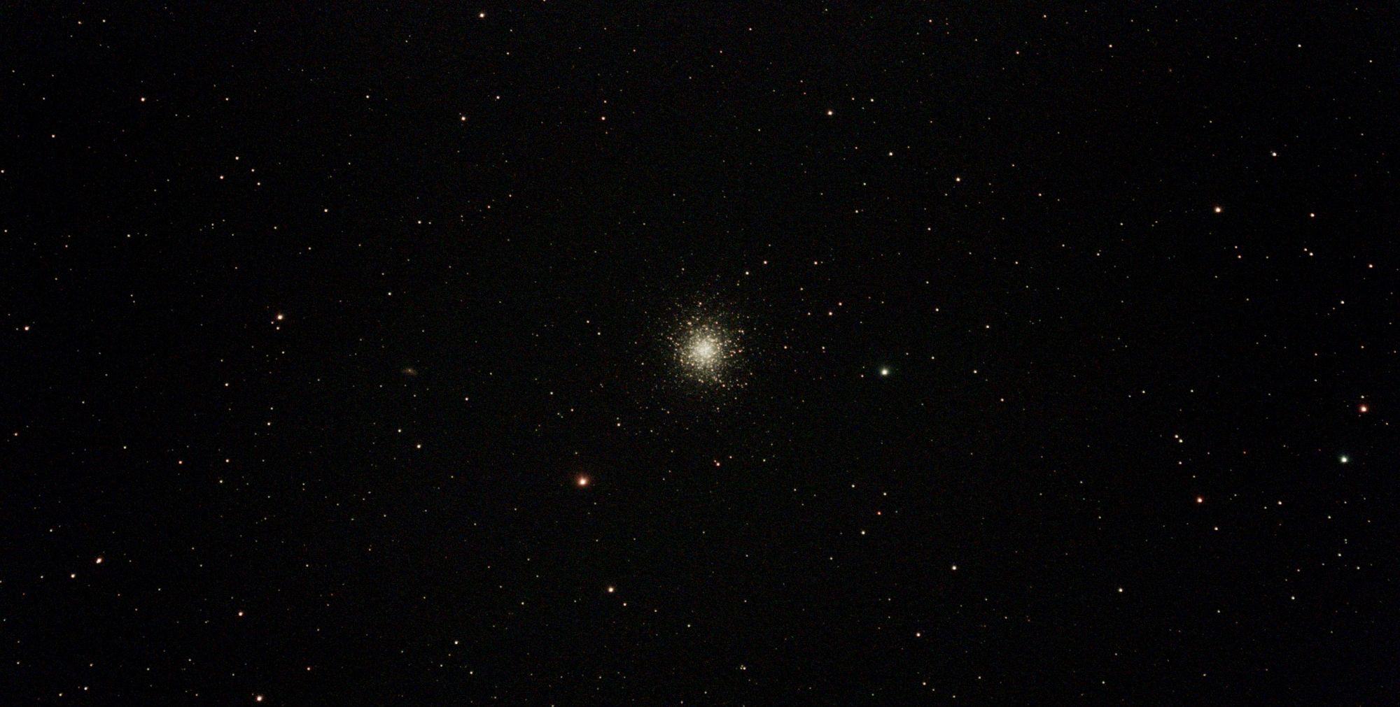M13, le grand amas globulaire d’Hercule, visible comme une concentration sphérique d’étoiles au centre d’un vaste champ stellaire